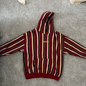 Rue 21 “Culture” Maroon, White, Yellow, and Black striped hoodie. Size: L